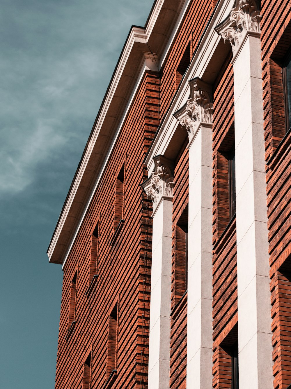 a tall red brick building with white columns