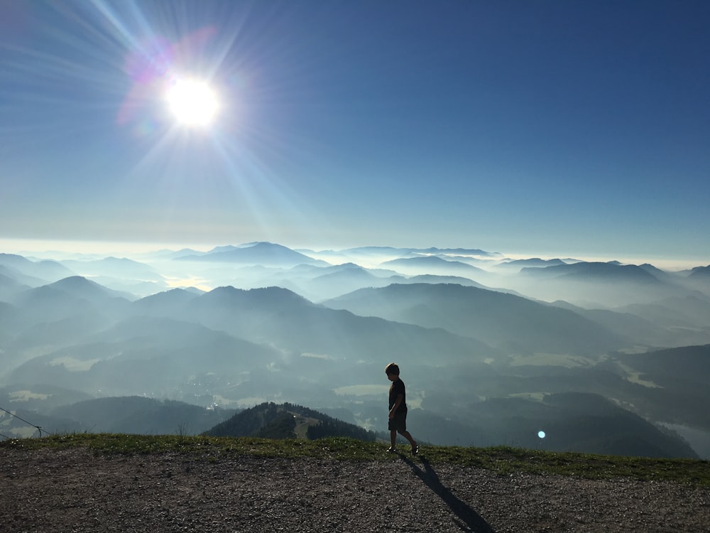 boy walking near mountains