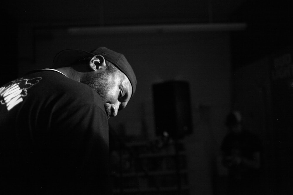 a black and white photo of a man wearing a hat