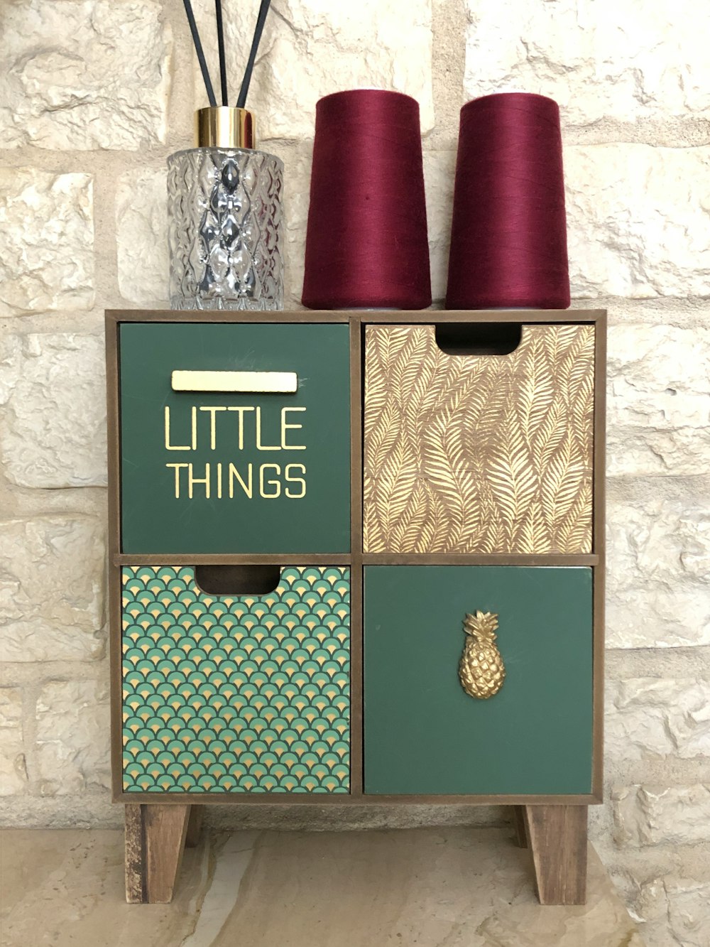 two maroon sewing threads on cube shelf