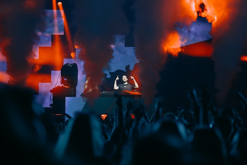 A dynamic photo of dj rodix performing live with colorful stage lights illuminating the crowd