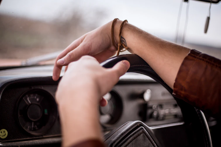 Close-up of the smilemotion device clipped onto a purple steering wheel, glowing softly.