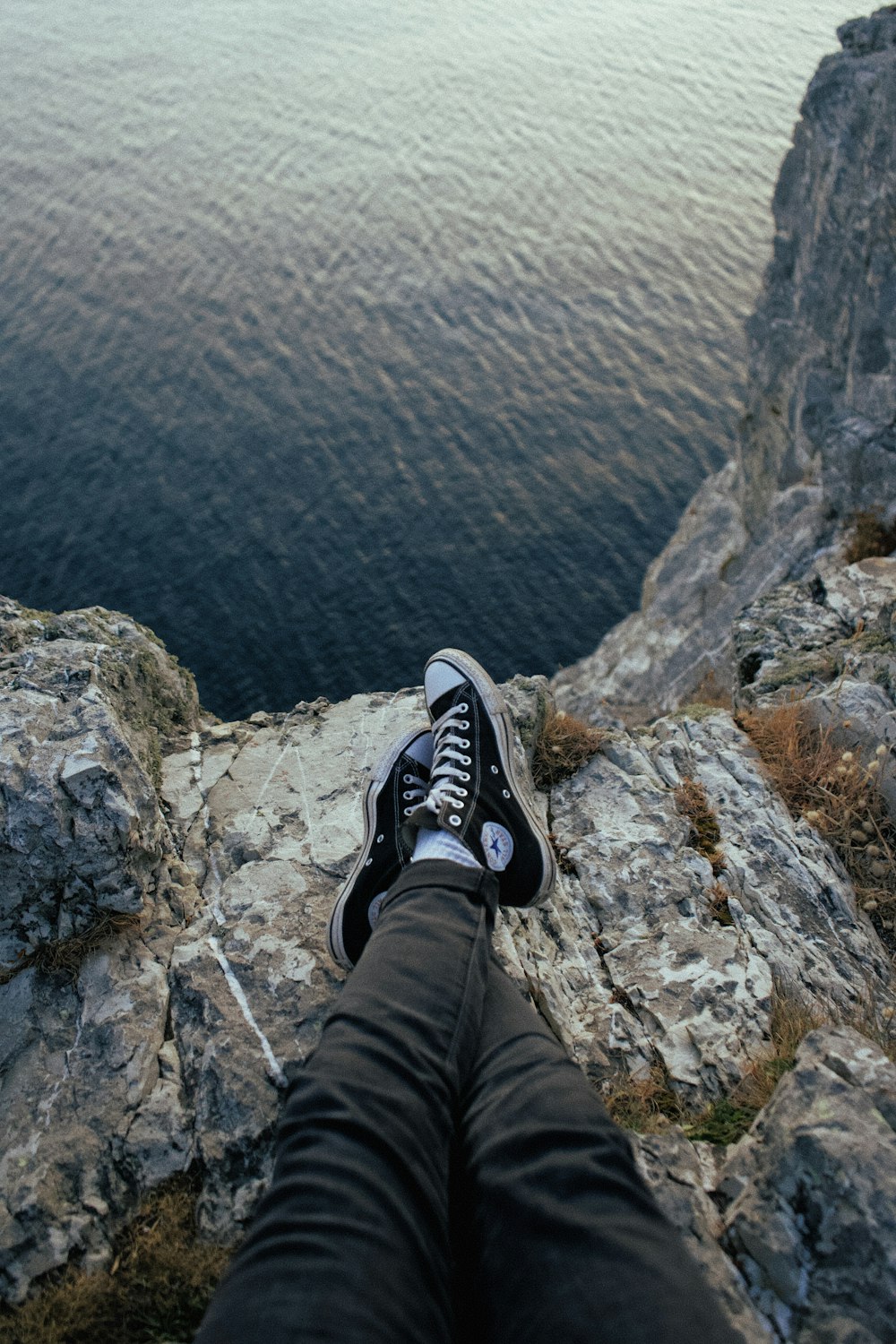 person wearing black-and-white Converse All-Star sneakers