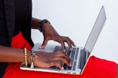 Close-up of hands typing on a laptop keyboard with a clean white background.