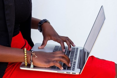 A close-up of a journalist typing on a laptop with notes about human rights.