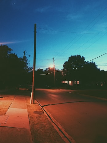 A sleek standby generator installed beside a cozy suburban home at dusk, softly illuminated by porch lights.