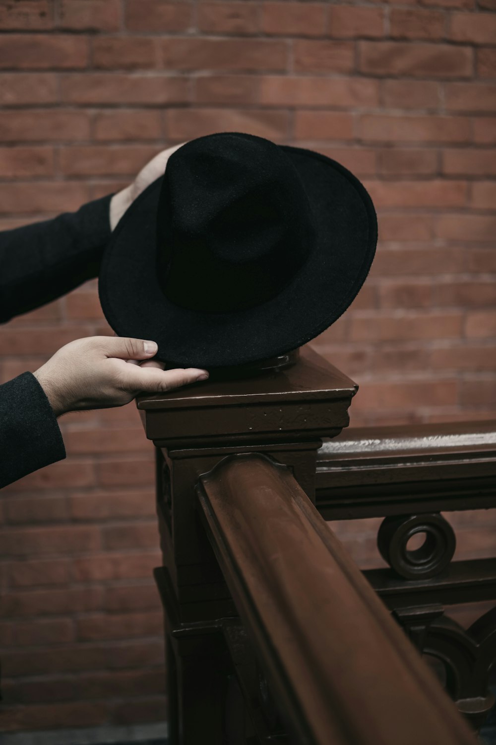 person holding black hat