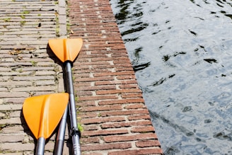 pair of yellow and silver paddles on gray surface