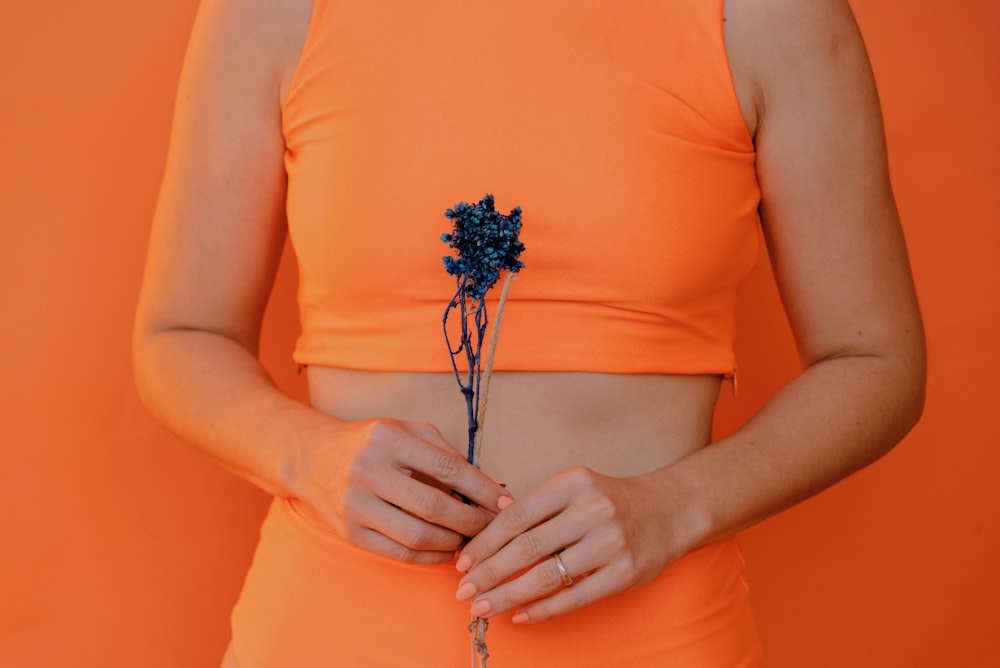 mujer sosteniendo una flor de pétalos azules