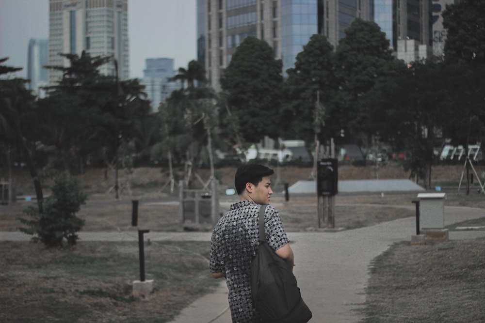 man in gray shirt standing on pathway