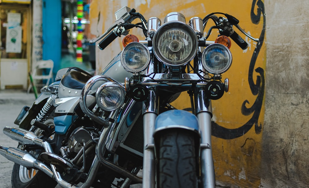 black and gray cruiser motorcycle beside yellow and brown wall