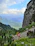 Photo of hikers enjoying a scenic trail with mountains in the background.