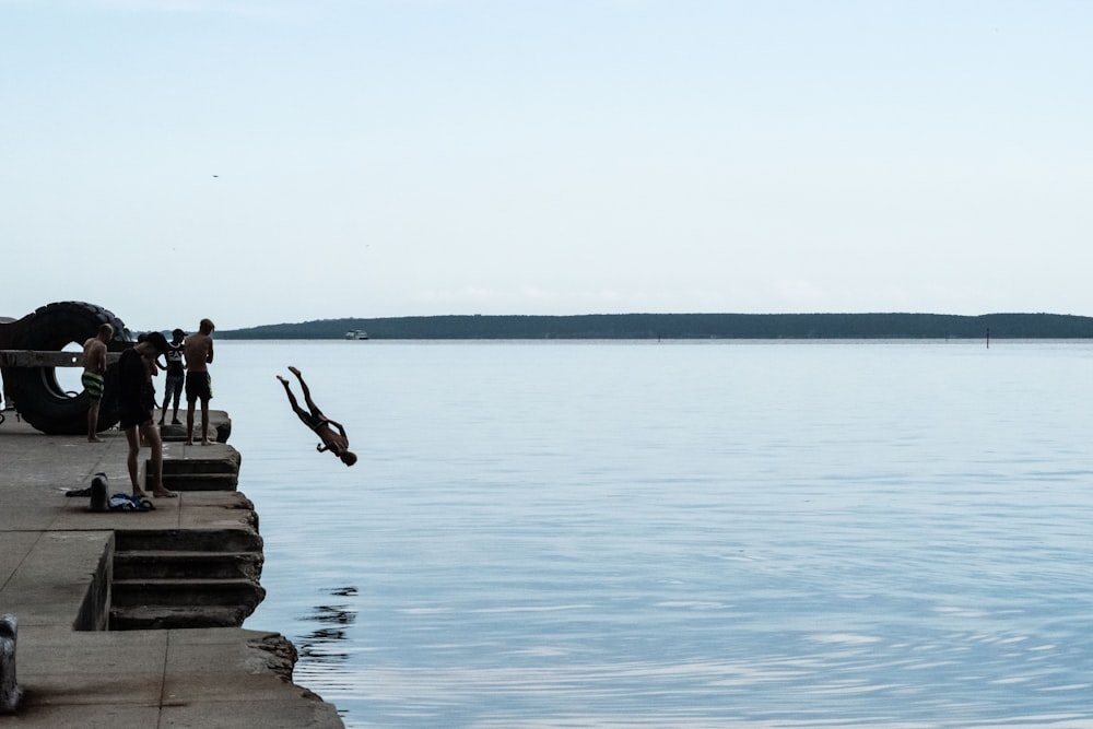 man diving head first from dock