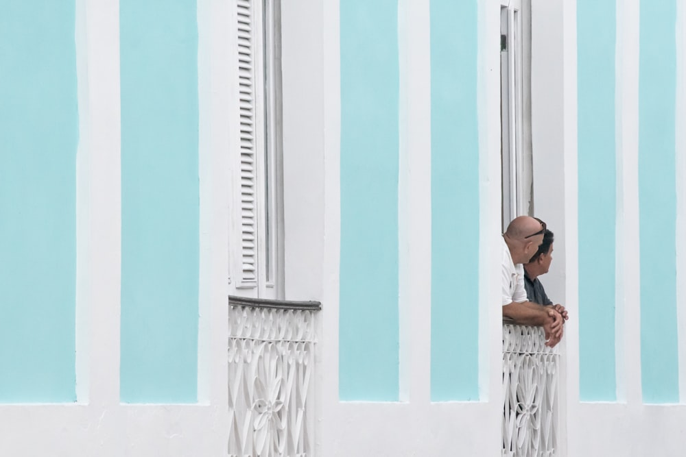 person wearing white shirt on white terrace fence