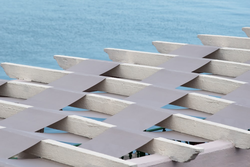 a close up of a metal structure with water in the background