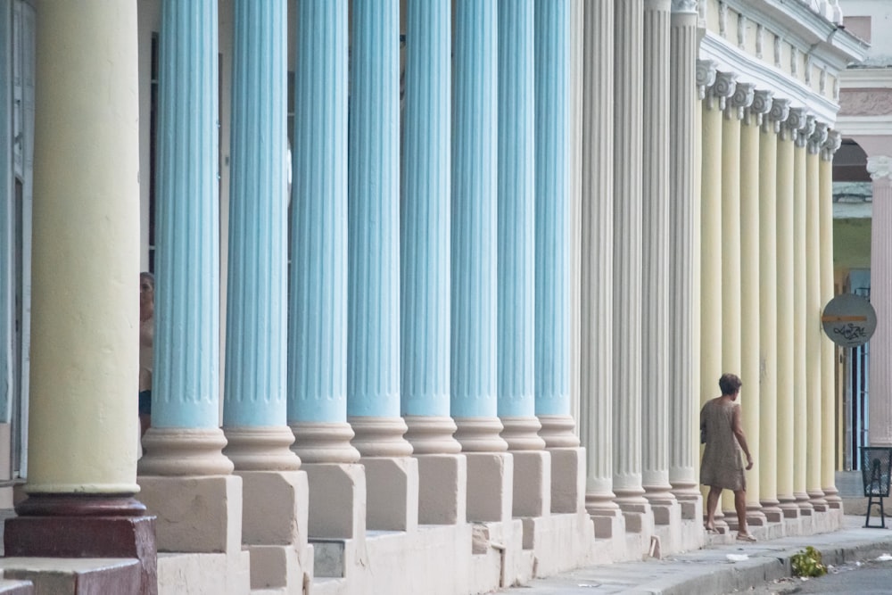 femme debout près des poteaux de colonne de bâtiment