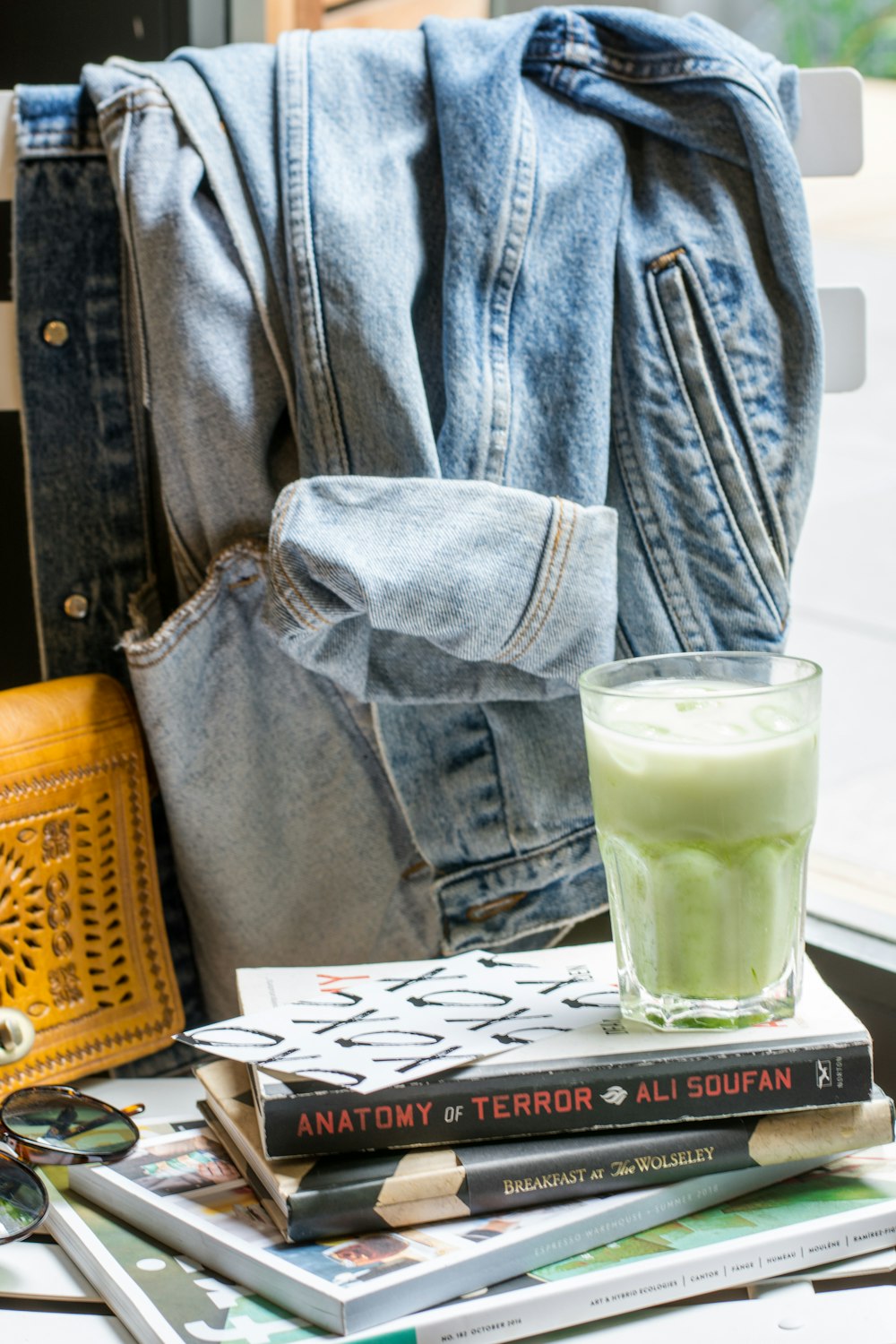 filled clear drinking glass near denim jacket