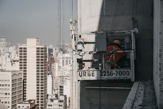 A skilled worker using akkora's suspension system on a tall building site, showcasing safety and efficiency.