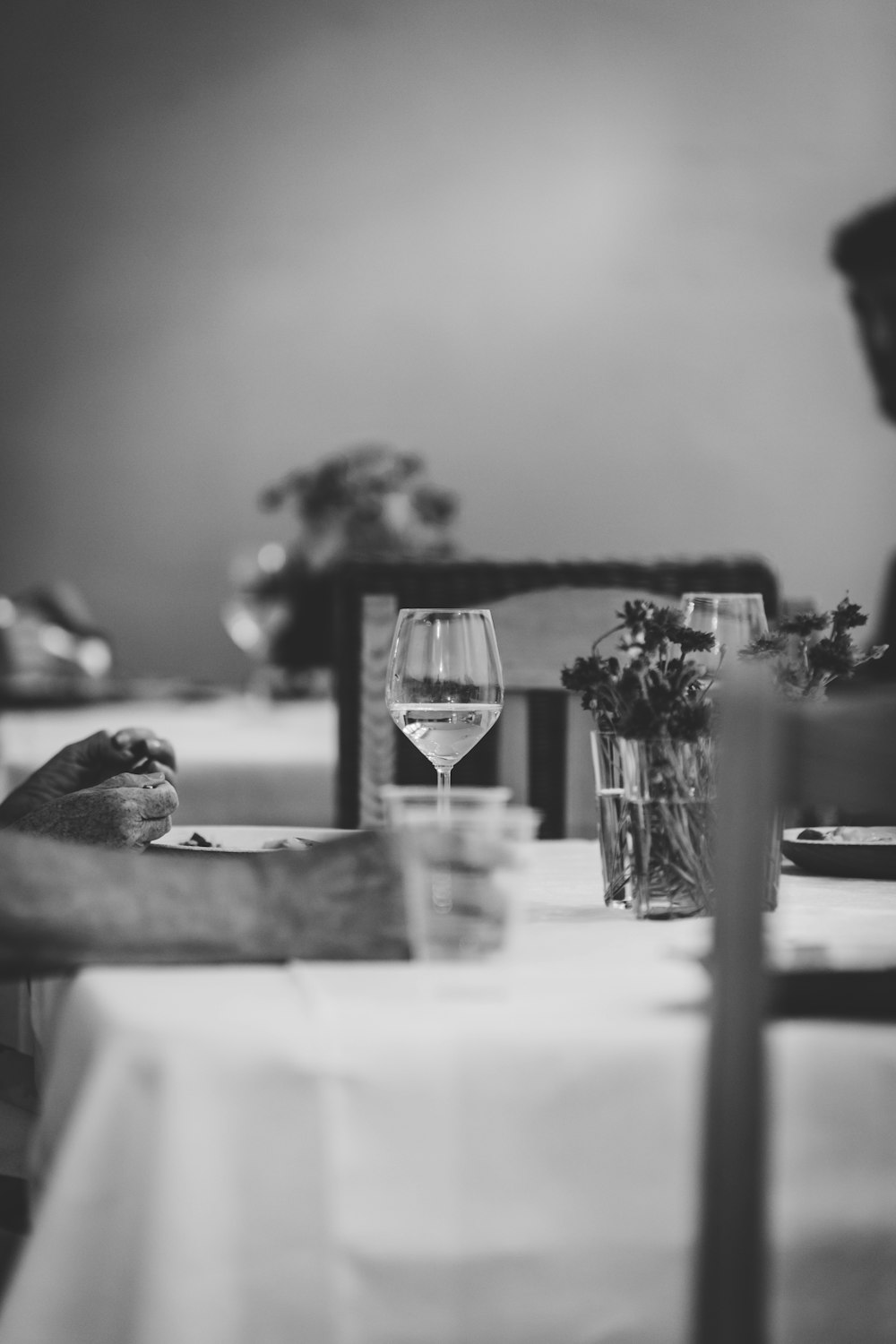 grayscale photography wine glass on top of table