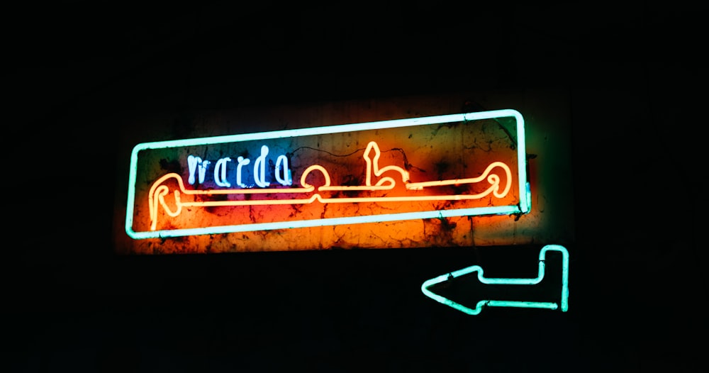 red and black neon sign with arrow