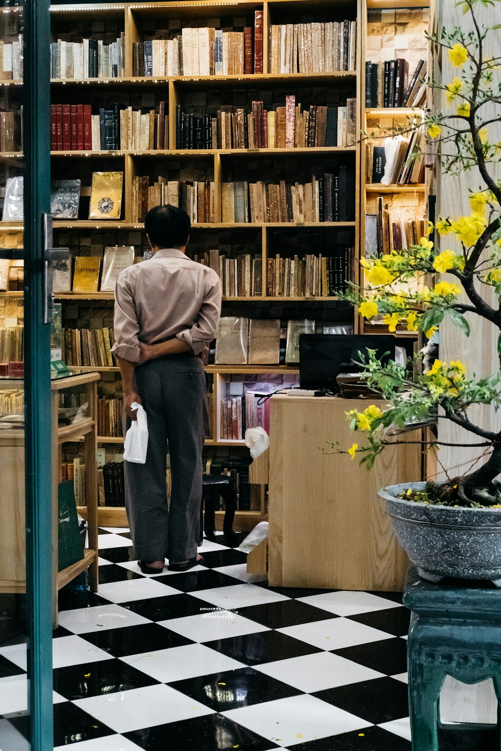 man standing near bookshelf