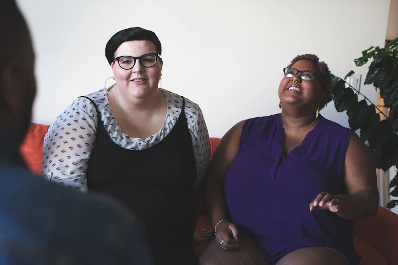 Two BBW women sharing a moment on a sofa