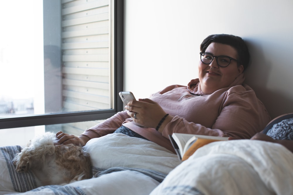 femme allongée sur le lit et appuyée sur le mur