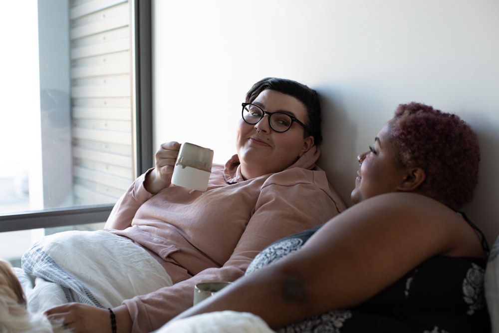 two woman lying on bed