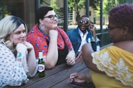 four people leaning on table