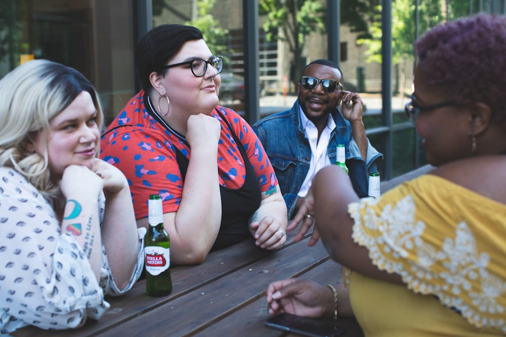 four people leaning on table