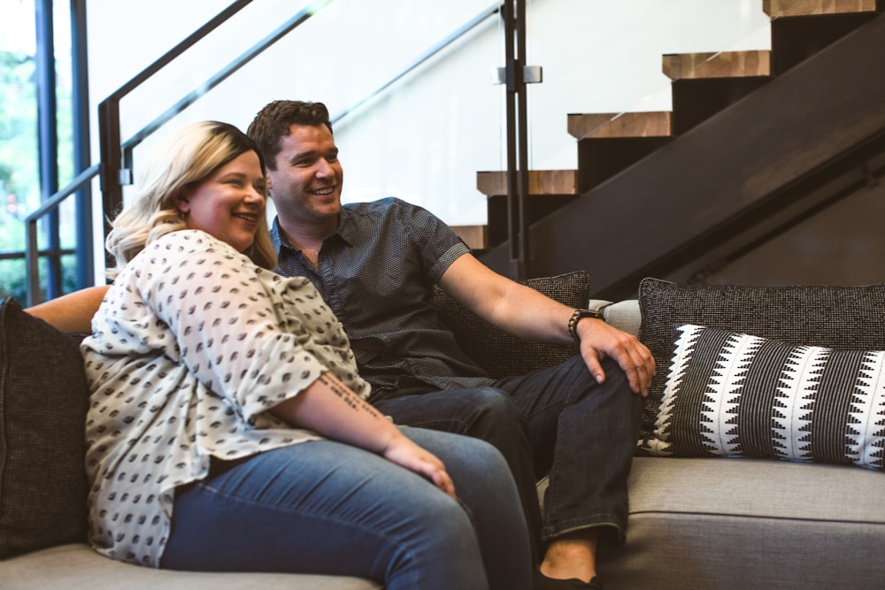 Mann und Frau sitzen lächelnd auf dem Sofa