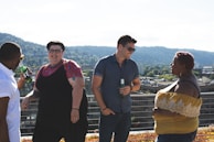 A group of men laughing together at a rooftop party.