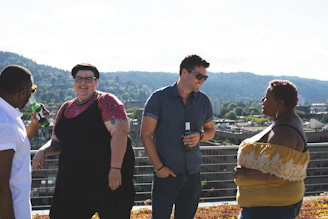 People enjoying drinks and laughter on a cozy rooftop deck.