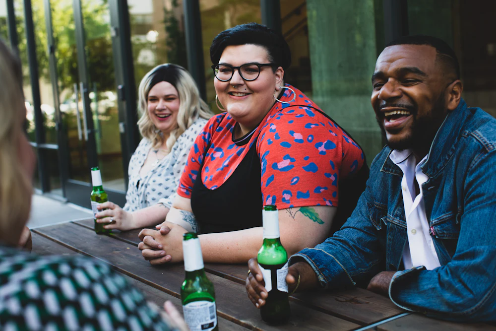 Friends drinking beers at a patio table