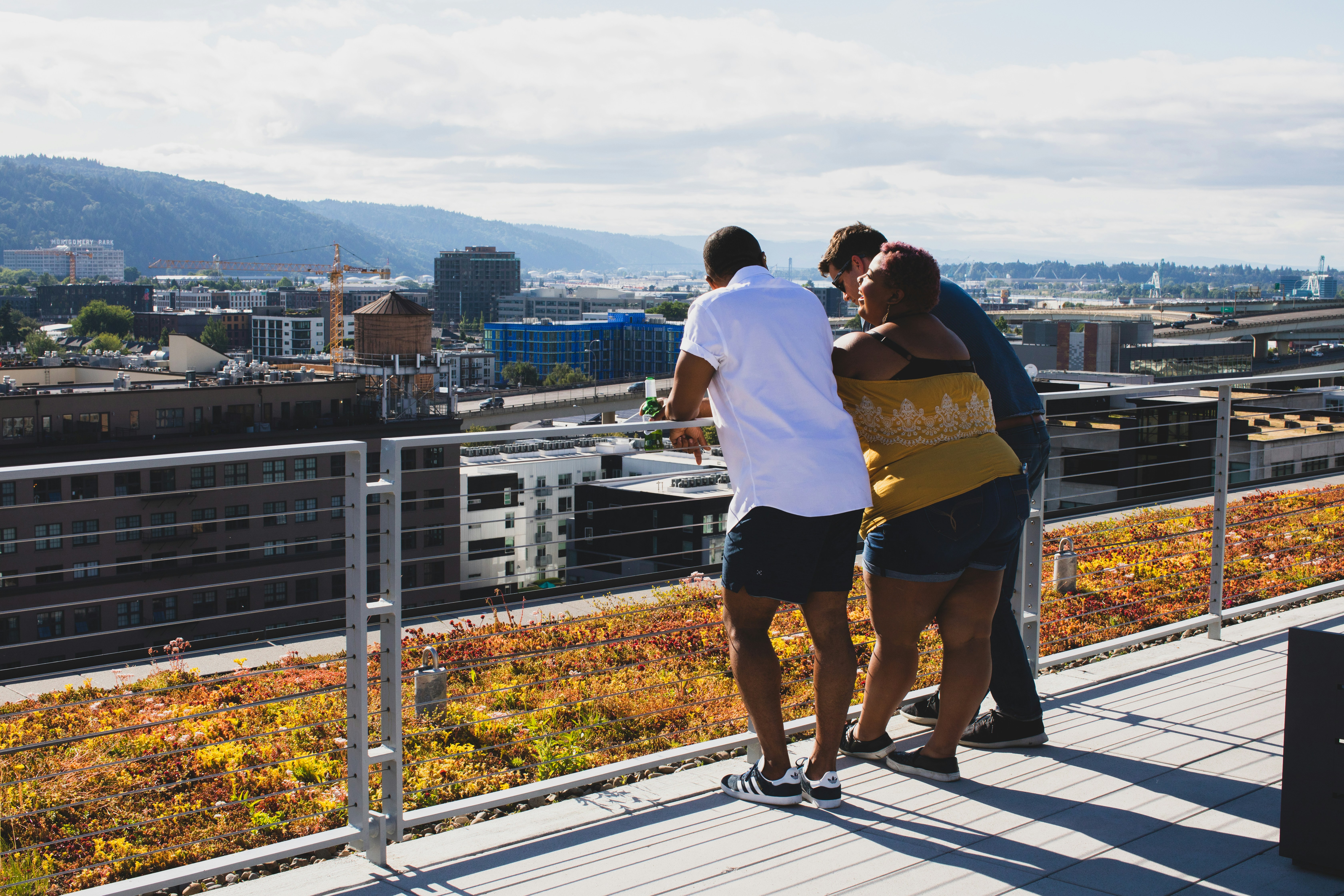 three people leaning on railing