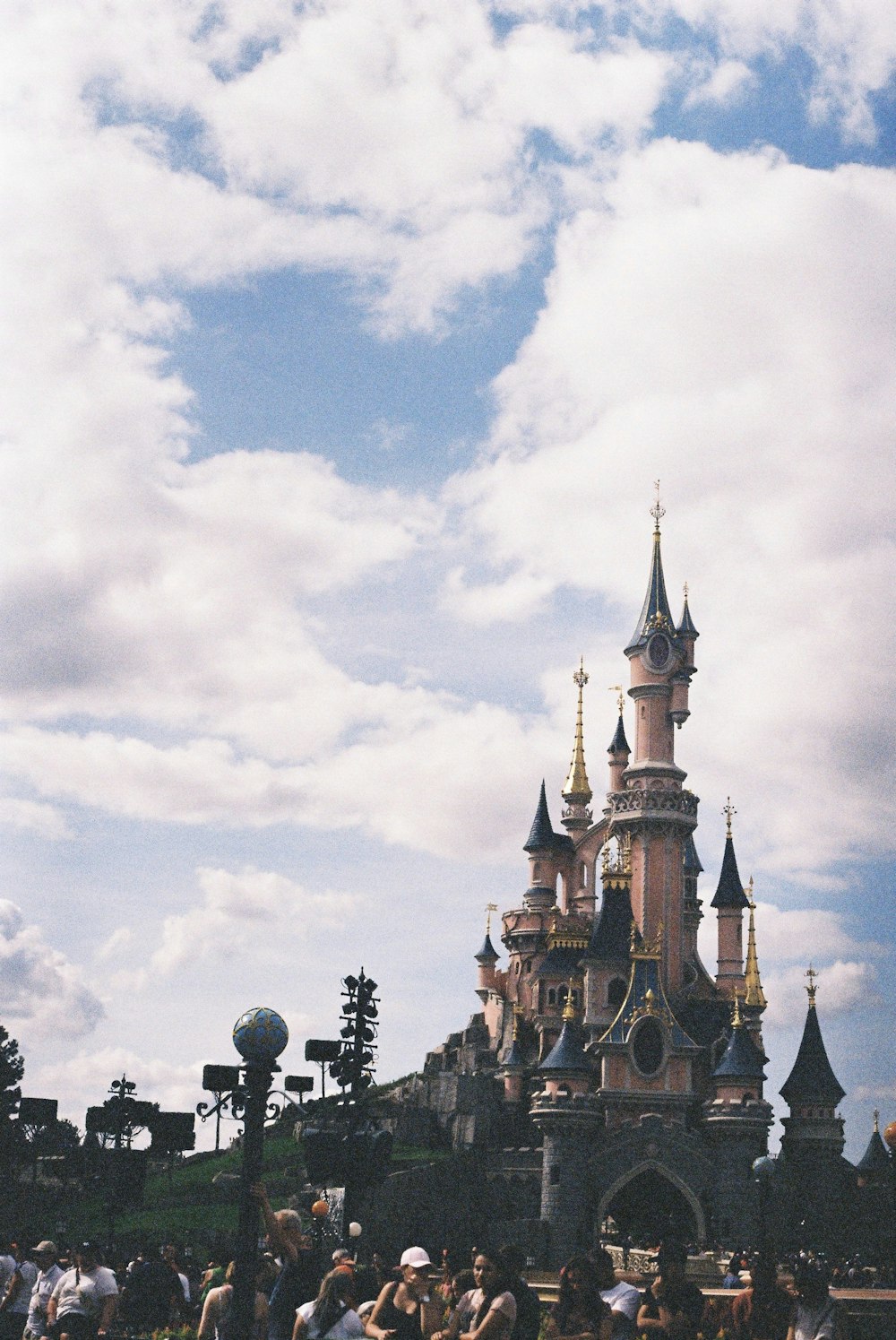 pink and blue Disneyland castle under white and blue cloudy sky