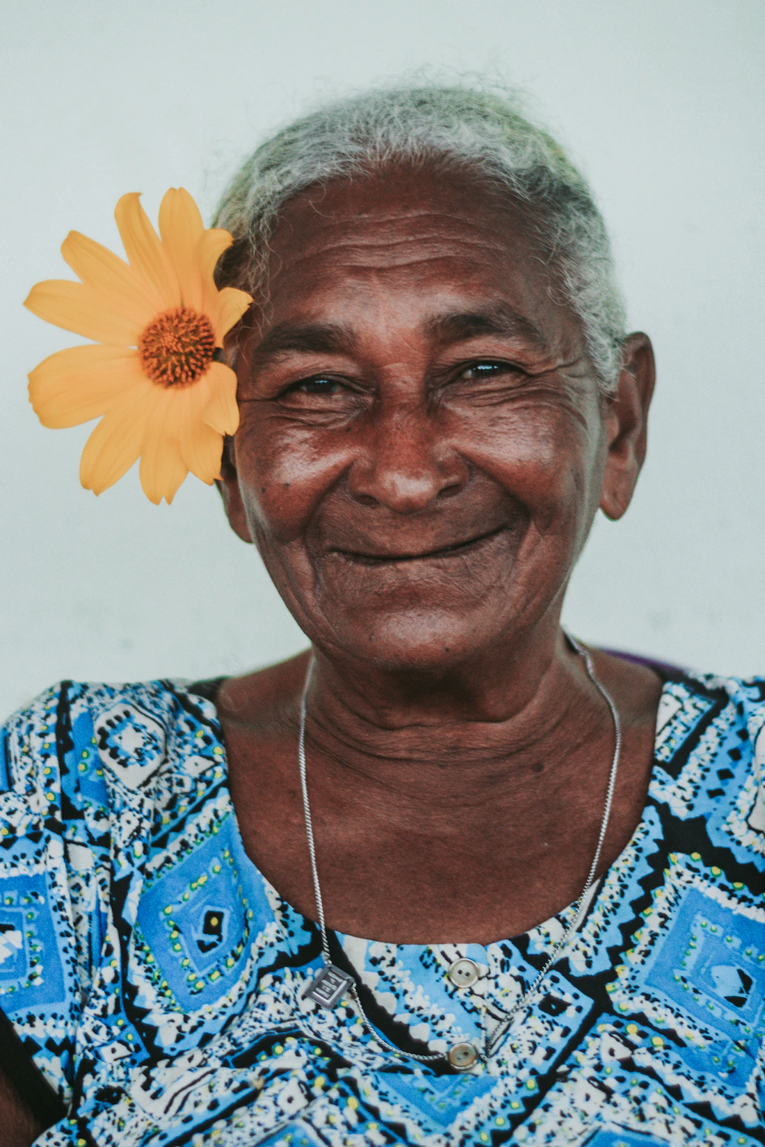 Senhora sorrindo com flor no cabelo