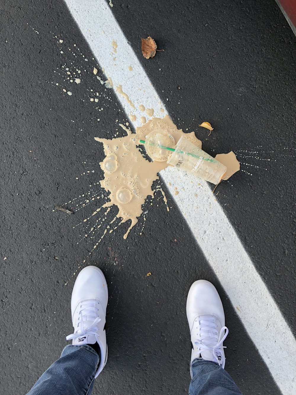 person standing on white line with cup on ground