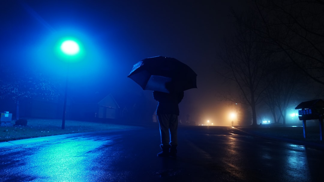 person standing under the black umbrella