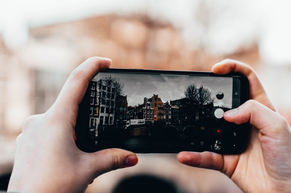 person holding phone selective focus photography