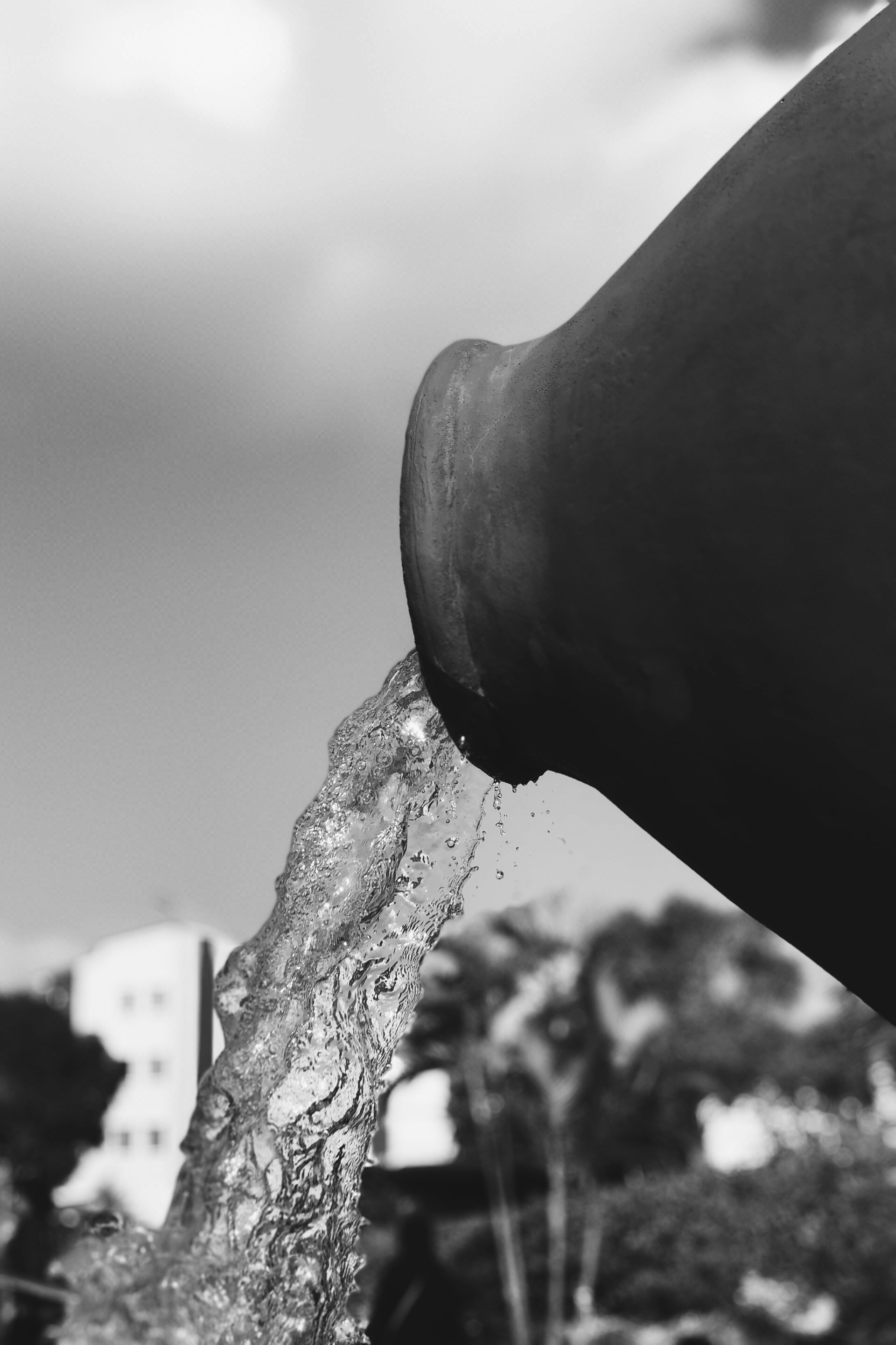 a black and white photo of a person's hand holding a water hose