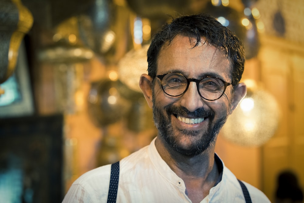 man wearing white shirt and eyeglasses smiling