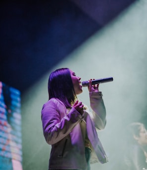 girl holding microphone close-up photography