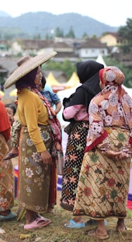 Women enjoying shopping outdoors in traditional Mexican dresses.