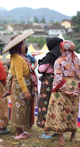 A group of women in a developing country engaged in a lively community discussion outdoors.