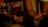 A close-up of hands gesturing with slightly open palms, alongside a part of an acoustic guitar. The scene is warmly lit, focusing on the expressive body language.