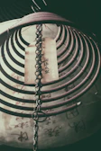 Artistic shot of scented bracelets hanging against a backdrop of ancient Chinese calligraphy
