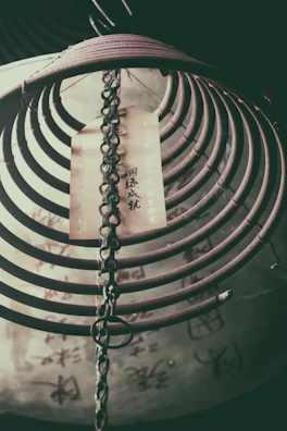 Artistic shot of scented bracelets hanging against a backdrop of ancient Chinese calligraphy