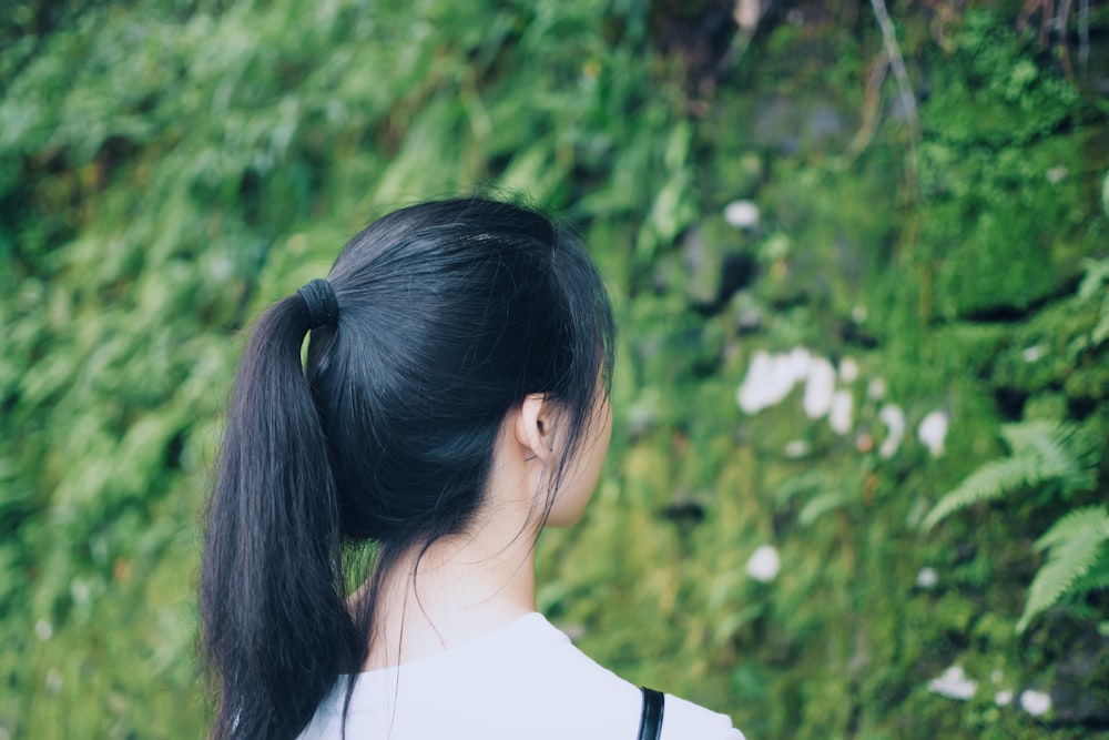 standing woman looking at green plants