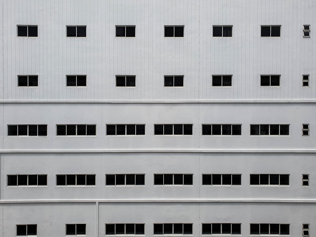 white concrete building with rows of glass windows